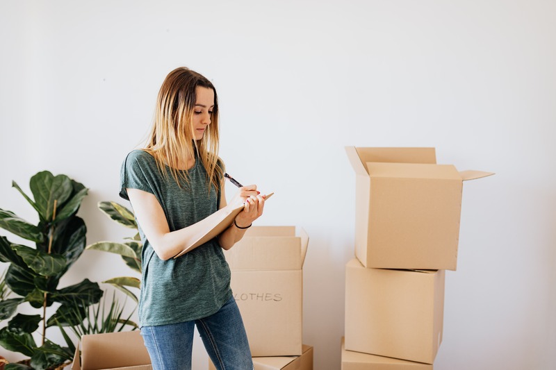 Woman with labeled boxes for storage: how to prevent mold in storage sheds