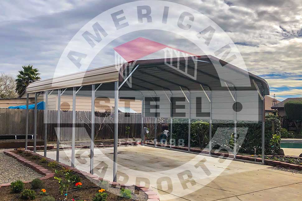 A carport with a vertical roof and a sign reading "American Steel Carports," showcasing its durable design.