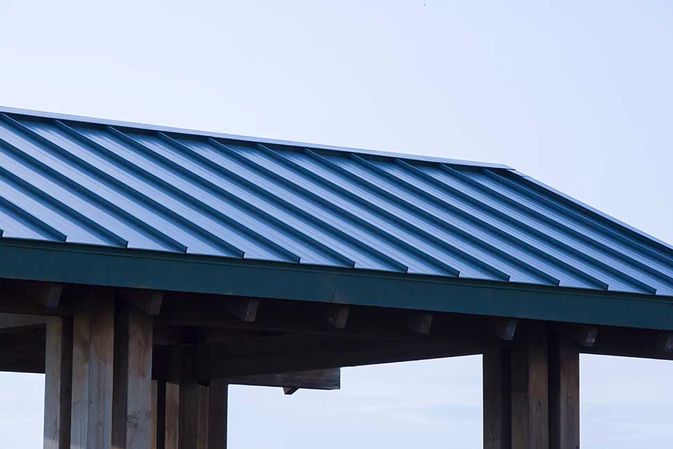 A wooden building featuring a blue metal roof, exemplifying a simple and economical roofing style.