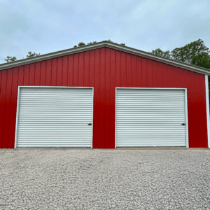 A two-car steel garage in Alvarado, TX, featuring dual white roll-up doors, delivered and installed by American Steel Carports, Inc.