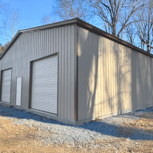 Clay clear span metal garage with two white roll-up doors and a side walk-in door, built in Addison, TX by American Steel Carports, Inc.