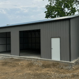 Pewter gray metal garage with two open bays, a white walk-in door, and vertical siding, installed in Albert Lea, Minnesota by American Steel Carports, Inc.