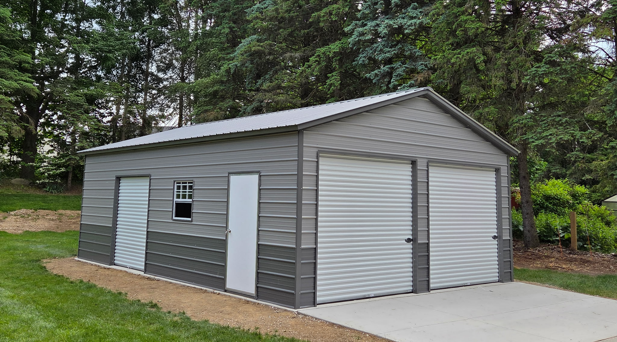 Side view of a two-car metal garage in Appleton, WI, showing seamless pewter gray steel siding and windowless wall design.
