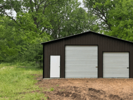Front view of a burnished slate two-car metal garage with white roll-up doors and a walk-in entry, installed in Allen, Texas by American Steel Carports, Inc.