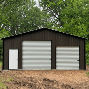 Front view of a burnished slate two-car metal garage with white roll-up doors and a walk-in entry, installed in Allen, Texas by American Steel Carports, Inc.