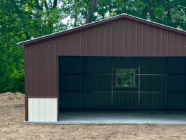 Front view of a two-tone metal garage in Ames, IA with earth brown upper panels, pebble beige lower panels, and a centered window, built by American Steel Carports, Inc.